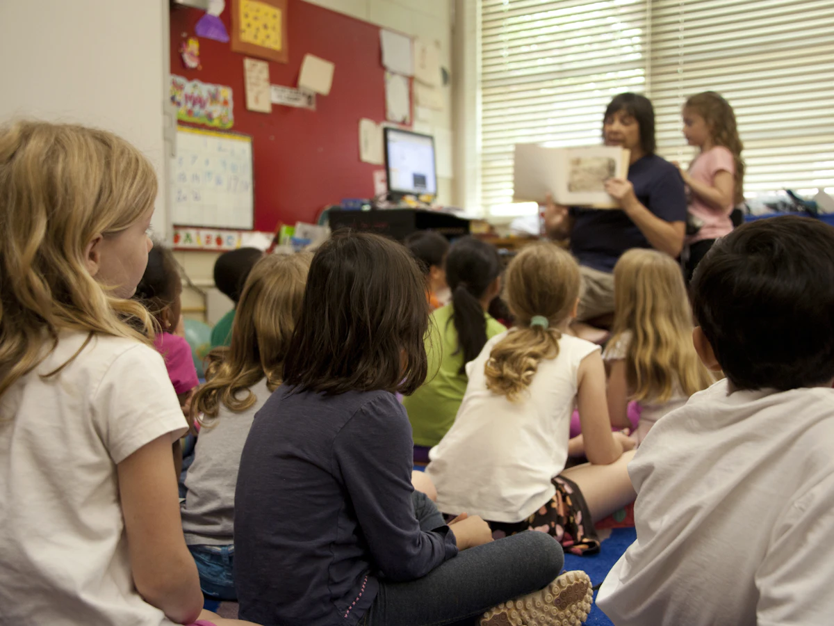Children sitting on a classroom floor listening to a story