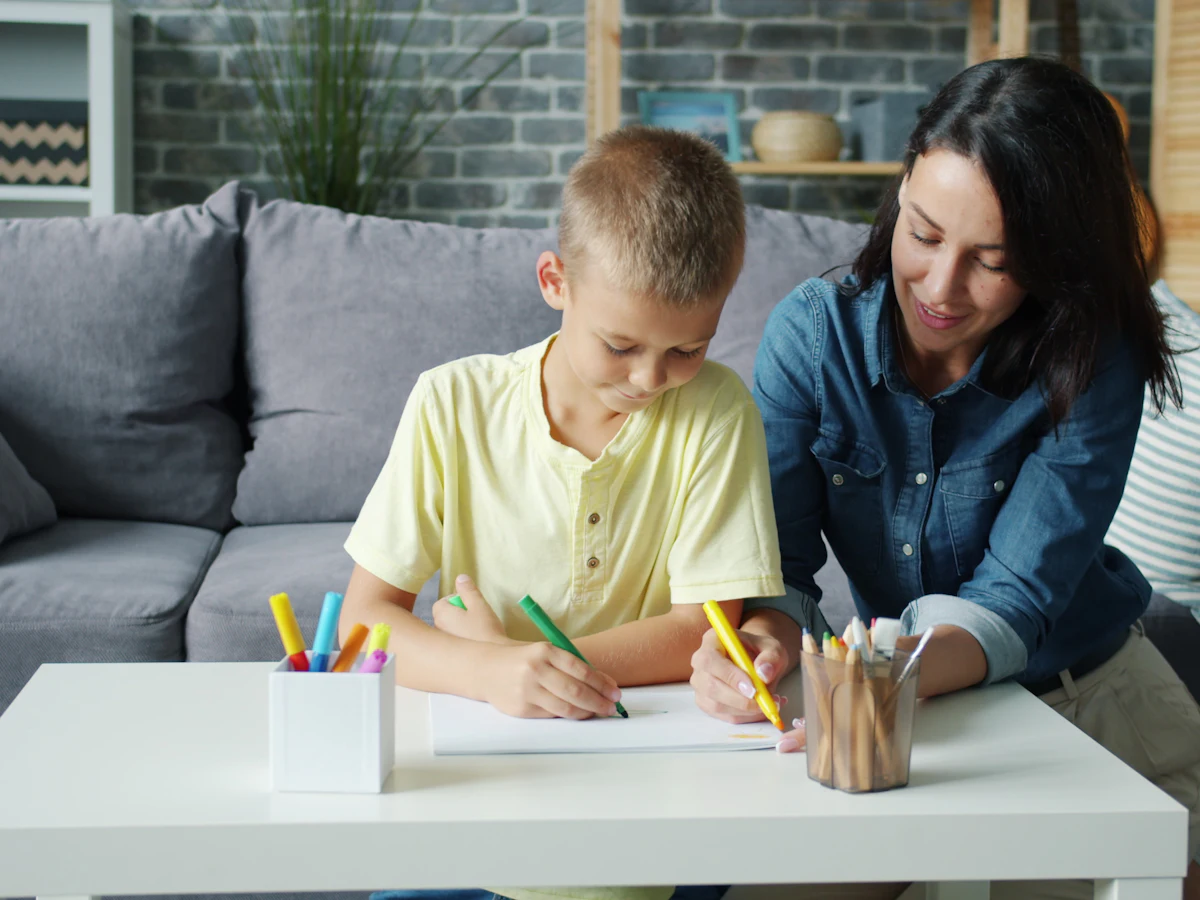A mother and son drawing together at a table